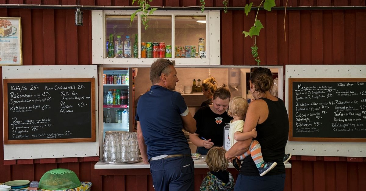 Familj beställer mat på sommarcafé i Blekinge med lokala specialiteter