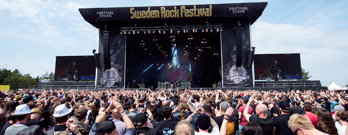 Publikhav framför huvudscenen på Sweden Rock Festival, en av världens mest ikoniska rockfestivaler i Sölvesborg, Sverige, med liveframträdanden från legendariska rockband.